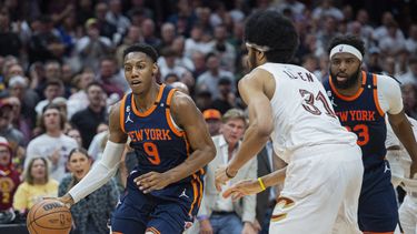 RJ Barrett (9), de los Knicks de Nueva York, conduce el balón frente a Jarrett Allen (31), de los Cavaliers de Cleveland, mientras Mitchell Robinson (23), de Nueva York, observa durante la segunda mitad del Juego 5 de la serie de primera ronda del baloncesto de la NBA, el miércoles 26 de abril de 2023, en Cleveland. Los Knicks ganaron 106-95 y se llevaron la serie. (AP Foto/Phil Long)