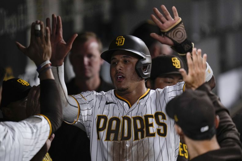 El dominicano Manny Machado, de los Padres de San Diego, celebra en la cueva tras anotar ante los Dodgers de Los Ángeles, el sábado 5 de agosto de 2023 (AP Foto/Gregory Bull)
