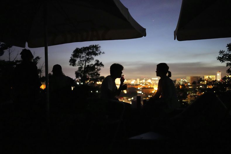 Personas en la terraza de un bar en Monte Agudo, en Lisboa, en medio del apagón del 28 de abril del 2025. (AP foto/Armando Franca)