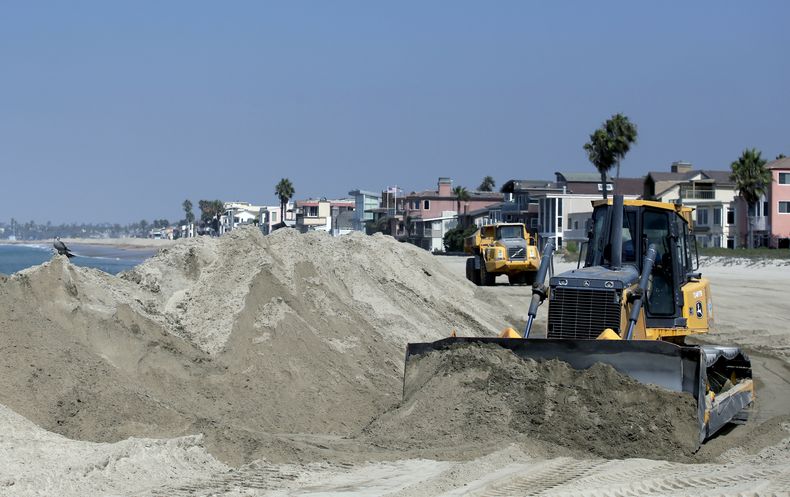 Una topadora apila arena para formar una barrera temporaria que proteja varias casas de playa del oleaje que se espera generar&aacute; el hurac&aacute;n Norbert, el viernes 5 de septiembre de 2014, en Long Beach, California. (Foto AP/Chris Carlson)
