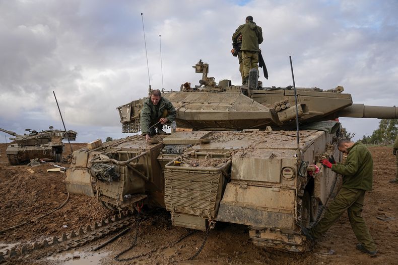 Soldados israelíes trabajan en un tanque en un puesto del ejército cerca de la frontera con Gaza, en el sur de Israel, el 27 de noviembre de 2023. (AP Foto/Ohad Zwigenberg)