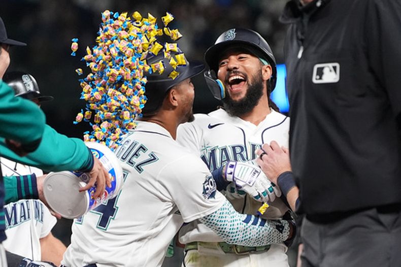 JP Crawford festeja con el dominicano Julo Rodríguez, su compañero en los Marineros de Seattle, después de resolver con un sencillo el duelo ante los Astros de Houston, el sábado 11 de abril de 2026 (AP Foto/Lindsey Wasson)
