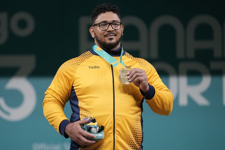 El colombiano Rafael Cerro posa con su medalla de oro en la división de 102 kilogramos del levantamiento de los Juegos Panamericanos en Santiago, Chile, el martes 24 de octubre de 2023. (AP Foto/Moisés Castillo)