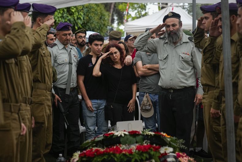 Soldados israelíes y Shlomit Lipshitz (centro), la madre del sargento Lavi Lipshitz, saluda la tumba de su hijo durante su funeral en el cementerio militar del Monte Herzl, en Jerusalén, el 1 de noviembre de 2023. (AP Foto/Ohad Zwigenberg)
