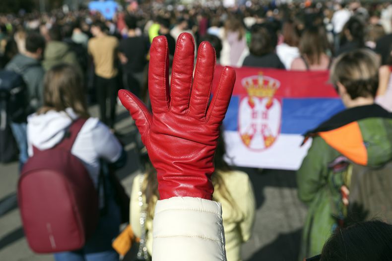 Una mujer levanta un guante rojo como símbolo de sangre, en las protestas por denuncias que la corrupción permitió la mala construcción de un techo que colapsó, en Belgrado, Serbia, el 27 de enero del 2025. (AP foto/Darko Vojinovic)