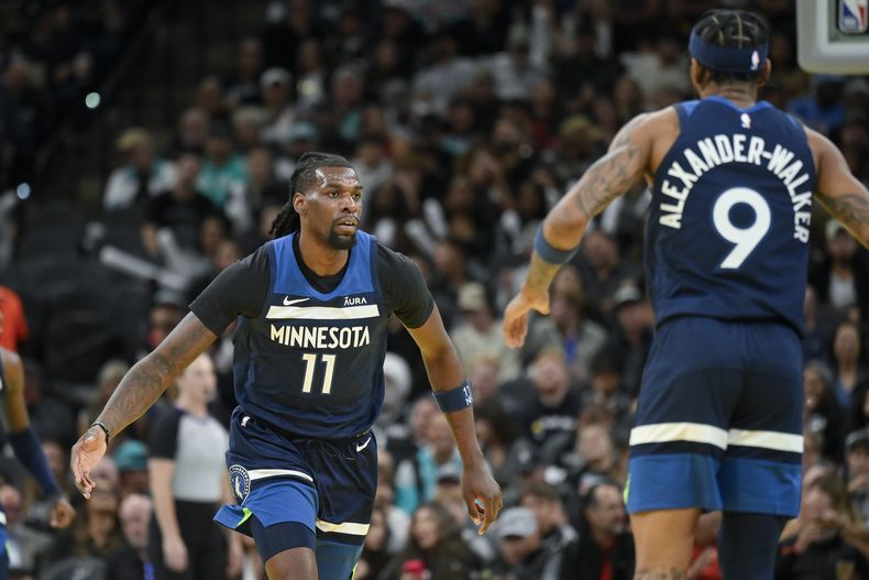 Naz Reid, de los Timberwolves de Minnesota, festeja con su compañero Nickeil Alexander-Walker durante el encuentro del viernes 10 de noviembre de 2023 (AP Foto/Darren Abate)