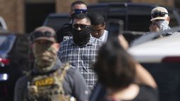 Agentes federales escoltan a un hombre a un autobús después de ser detenido después de una comparecencia en la corte de inmigración, el lunes 28 de julio de 2025, en San Antonio. (AP Foto/Eric Gay)