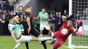 El portero del LAFC John McCarthy salta para intentar bloquear el disparo del mediocampista del León Lucas Di Yorio y el defensa del LAFC Aaron Long observa en el duelo de vuelta de la final de la Liga de Campeones CONCACAF el domingo 4 de junio del 2023. (AP Foto/Marcio Jose Sanchez)