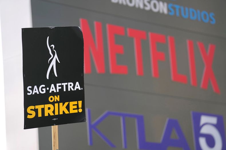 ARCHIVO - Un manifestante porta un cartel en una protesta frente a Netflix el miércoles 27 de septiembre de 2023 en Los Ángeles. (Foto AP/Chris Pizzello, archivo)