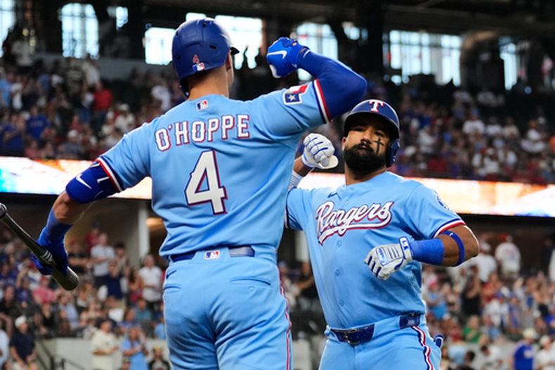 Logan OHoppe (4) y Ezequiel Durán, derecha, de los Rangers de Texas, celebran el jonrón solitario de Durán en la segunda entrada del juego de béisbol de Grandes Ligas contra los Angelinos de Los Ángeles, el domingo 23 de agosto de 2026, en Arlington, Texas. (AP Foto/Tony Gutierrez)