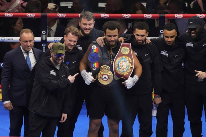 ARCHIVO - El británico Moses Itauma, centro, celebra después de derrotar al australiano Demsey McKean en su combate de boxeo en Riad, Arabia Saudita, el 21 de diciembre de 2024. (AP Foto/Frank Augstein, Archivo)