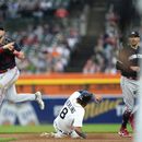 Kyle Farmer (12), segunda base de los Mellizos de Minnesota, lanza para completar un doble play mientras que Matt Vierling (8), de los Tigres de Detroit, se barre en segunda, en la sexta entrada del juego de béisbol, el viernes 23 de junio de 2023, en Detroit. (AP Foto/Paul Sancya)