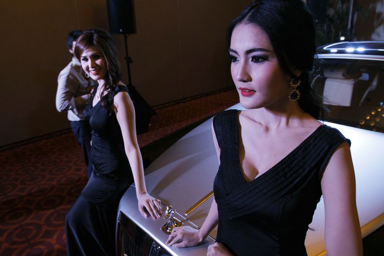 Modelos posan junto a un autom&oacute;vil de Rolls-Royce durante la inauguraci&oacute;n oficial de su concesionario en Phnom Penh, la capital de Camboya, el lunes, 9 de junio del 2014.  (Foto AP/Heng Sinith)