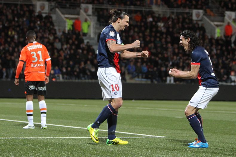 El sueco Zlatan Ibrahimovic (centro) y su compa&ntilde;ero uruguayo del Par&iacute;s Saint-Germain, Edinson Cavani, festejan el gol, en un partido de la liga francesa contra el Lorient, el viernes 21 de marzo de 2014 (AP Foto/David Vincent)