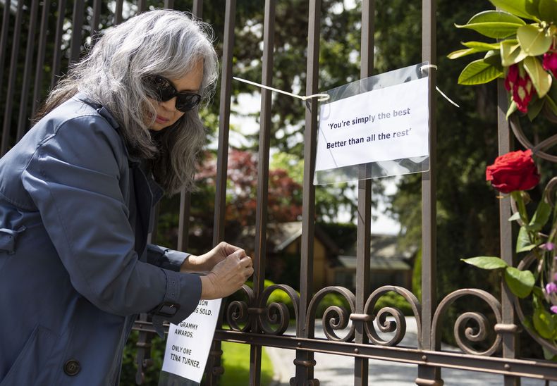 Una mujer no identificada fija notas en la puerta de la casa de la difunta cantante y actriz Tina Turner en Küsnacht, Suiza, el jueves 25 de mayo de 2023. Turner murió el miércoles 24 de mayo de 2023 tras una larga enfermedad en su casa en Küsnacht cerca de Zúrich, Suiza. Tenía 83 años. (Foto AP/Arnd Wiegmann)