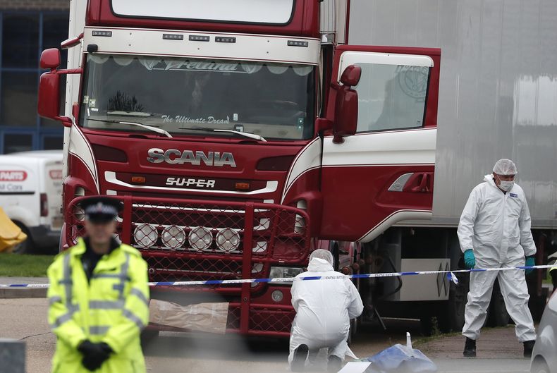 ARCHIVO - Agentes forenses trabajan en un camión que contenía una gran cantidad de cadáveres, en Grays, Inglaterra, 23 de octubre de 2019. Un rumano miembri de una banda internacional de contrabandistas de migrantes fue condenado el martes 11 de julio de 2023 a más de 12 años de prisión por la muerte de 39 migrantes vietnamitas hallados en un tractocamión en Inglaterra en 2019. Marius Mihai Draghici, de 50 años, se declaró culpable de homicidio por negligencia y asociación ilícita para la inmigración ilegal. (AP Foto/Alastair Grant, File)