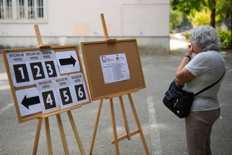 Una mujer consulta su lugar de votación en una casilla electoral para los comicios municipales de Portugal, el domingo 12 de octubre de 2025, en Lisboa. (AP Foto/Armando Franca)