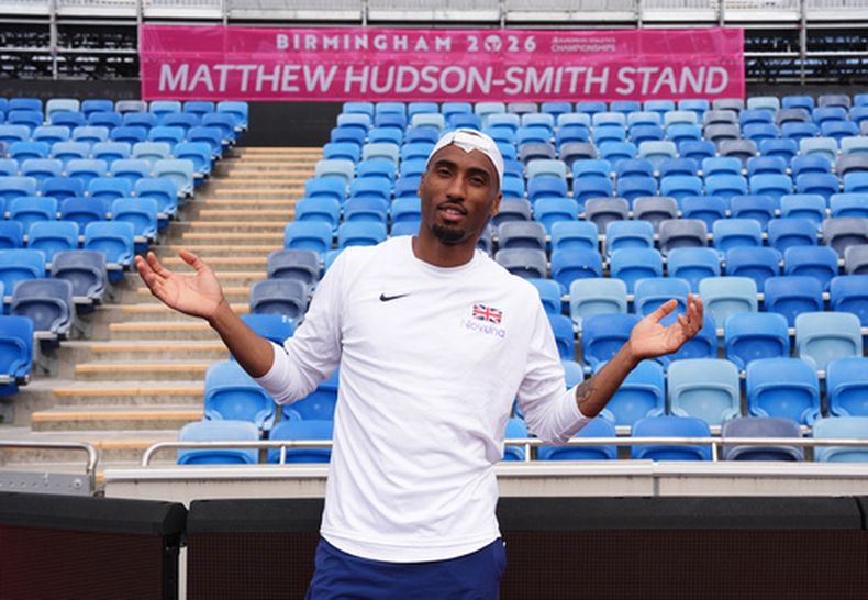 El británico Matthew Hudson-Smith posa frente a una tribuna que lleva su nombre durante una sesión de entrenamiento previa al inicio del Campeonato Europeo de Atletismo en Birmingham, Inglaterra, el domingo 9 de agosto de 2026. (Martin Rickett/PA vía AP)