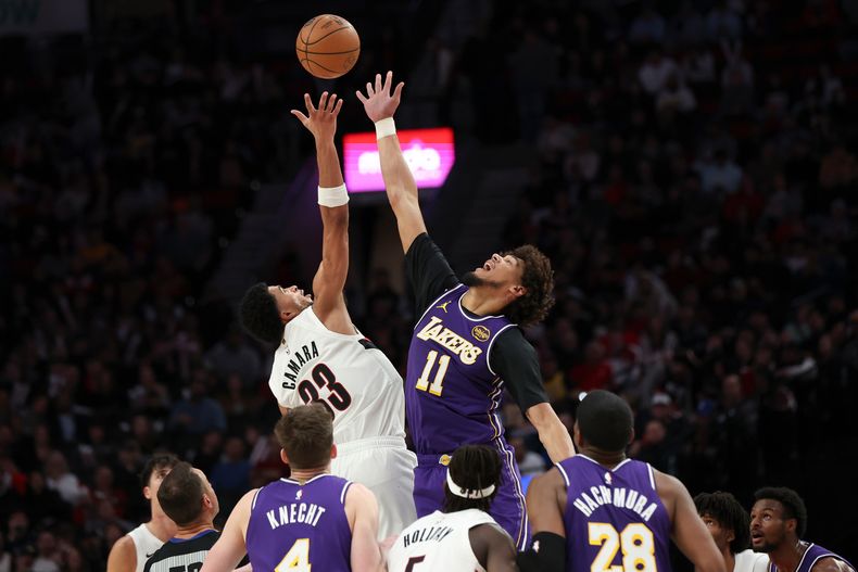 Jaxson Hayes (11), de los Lakers de Los Ángeles, y Toumani Camara (33), de los Trail Blazers de Portland, disputan un balón en lo alto durante el juego de baloncesto de la NBA, el lunes 3 de noviembre de 2025, en Portland, Oregon. (AP Foto/Amanda Loman)