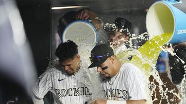 El venezolano Ezequiel Tovar (izquierda) y el mexicano Alan Trejo son empapados por sus compañeros tras la victoria sobre los Marlins de Miami, el jueves 25 de mayo de 2023 (AP Foto/David Zalubowski)