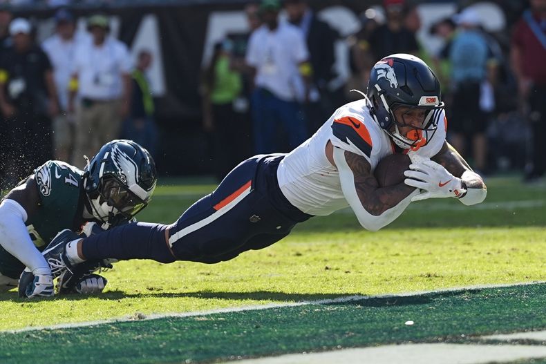 Evan Engram (1), ala cerrada de los Broncos de Denver, consigue un touchdown superando al safety Andrew Mukuba (24), de los Eagles de Filadelfia, durante la segunda mitad del partido de la NFL del domingo 5 de octubre de 2025, en Filadelfia. (AP Foto/Matt Rourke)