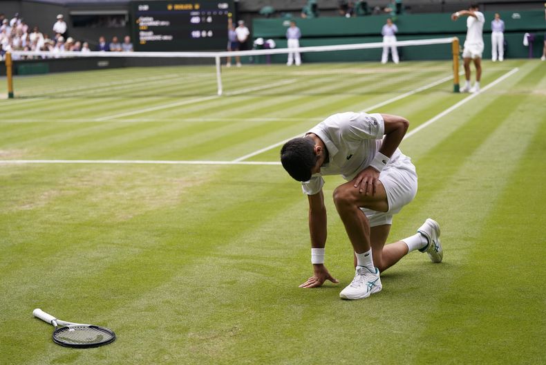 Novak Djokovic se arrodilla durante el partido contra Carlos Alcaraz por el título de Wimbledon, el domingo 16 de julio de 2023, en Londres. (AP Foto/Alberto Pezzali)