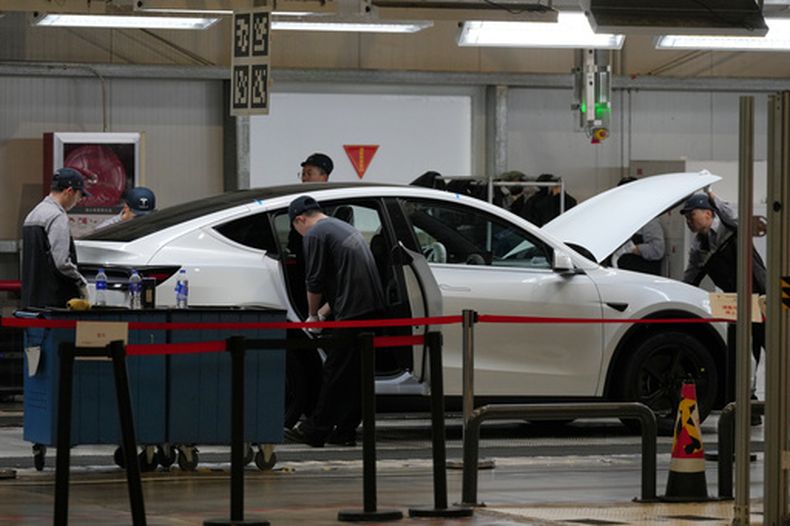 ARCHIVO – Varias personas trabajan en la línea de producción del Tesla Model Y en la planta de ensamblaje Tesla Gigafactory durante un recorrido organizado para los medios, en Shanghái, China, el martes 14 de abril de 2026. (AP Foto/Andy Wong, Archivo)