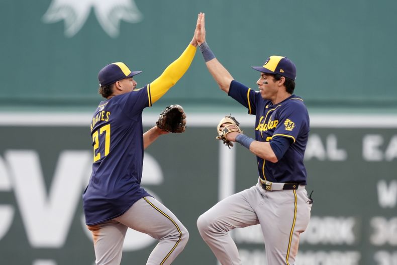 El dominicano Willy Adames (izquierda) y Christian Yelich festejan el triunfo de los Cerveceros de Milwaukee sobre los Medias Rojas de Boston, el sábado 25 de mayo de 2024 (AP Foto/Michael Dwyer)