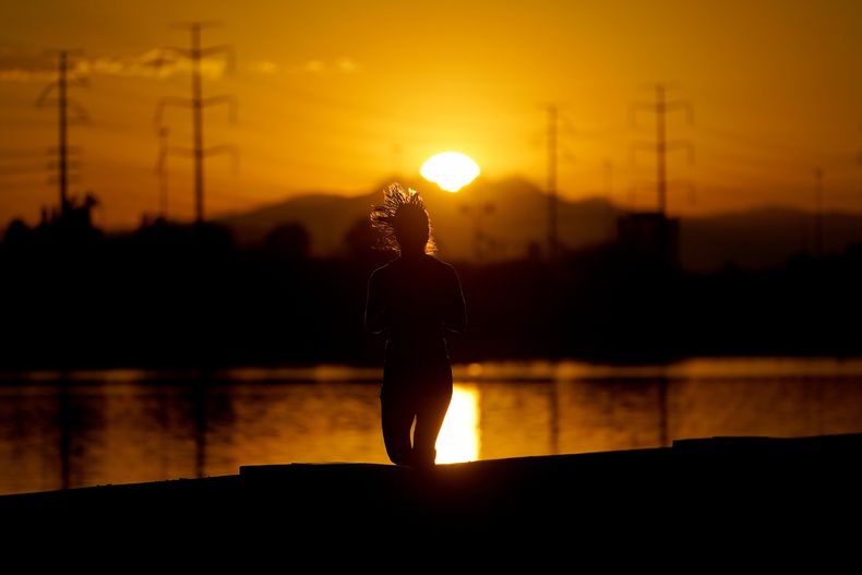 ARCHIVOS - Una muer corre cerca del Lago Tempe Town al amanecer, el 12 de julio de 2023 en Tempe, Arizona. (AP Foto/Matt York, archivo)
