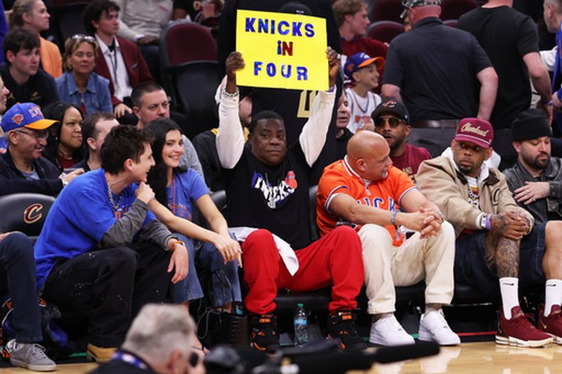 Tracy Morgan sostiene un letrero sentado junto a Timothée Chalamet y Kylie Jenner en la primera fila del encuentro de los Knicks de Nueva York ante los Cavaliers de Cleveland en el juego 4 de las finales de la Conferencia Este en el Madison Square Garden el lunes 25 de mayo del 2026. (AP Foto/Tim Phillis)