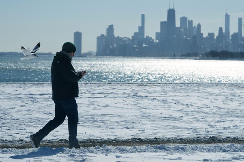 ARCHIVO – Una persona camina cerca de la arena cubierta de nieve en el lago Michigan en Chicago, el 28 de enero de 2026. (AP Foto/Nam Y. Huh, Archivo)