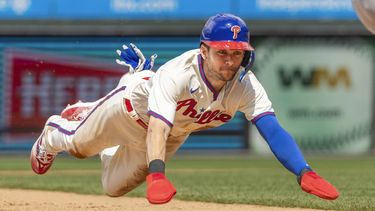 Trea Turner de los Filis de Filadelfia se roba la tercera base camino a anotar con una remolcada de Nick Castellanos en la quinta entrada del encuentro ante los Mets de Nueva York el domingo 25 de junio del 2023. (AP Foto/Laurence Kesterson)