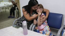 Israelíes se ponen a cubierto en un refugio mientras las sirenas antiaéreas advierten de proyectiles disparados desde la Ciudad de Gaza, en Ashkelon, Israel, el 10 de octubre de 2023. (AP Foto/Ohad Zwigenberg)