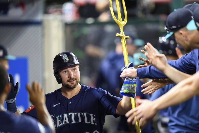 Cal Raleigh de los Marineros de Seattle es saludado por sus compañeros tras batear un jonrón en la sexta entrada ante los Angelinos de Los Ángeles el sábado 26 de julio del 2025. (AP Foto/William Liang)