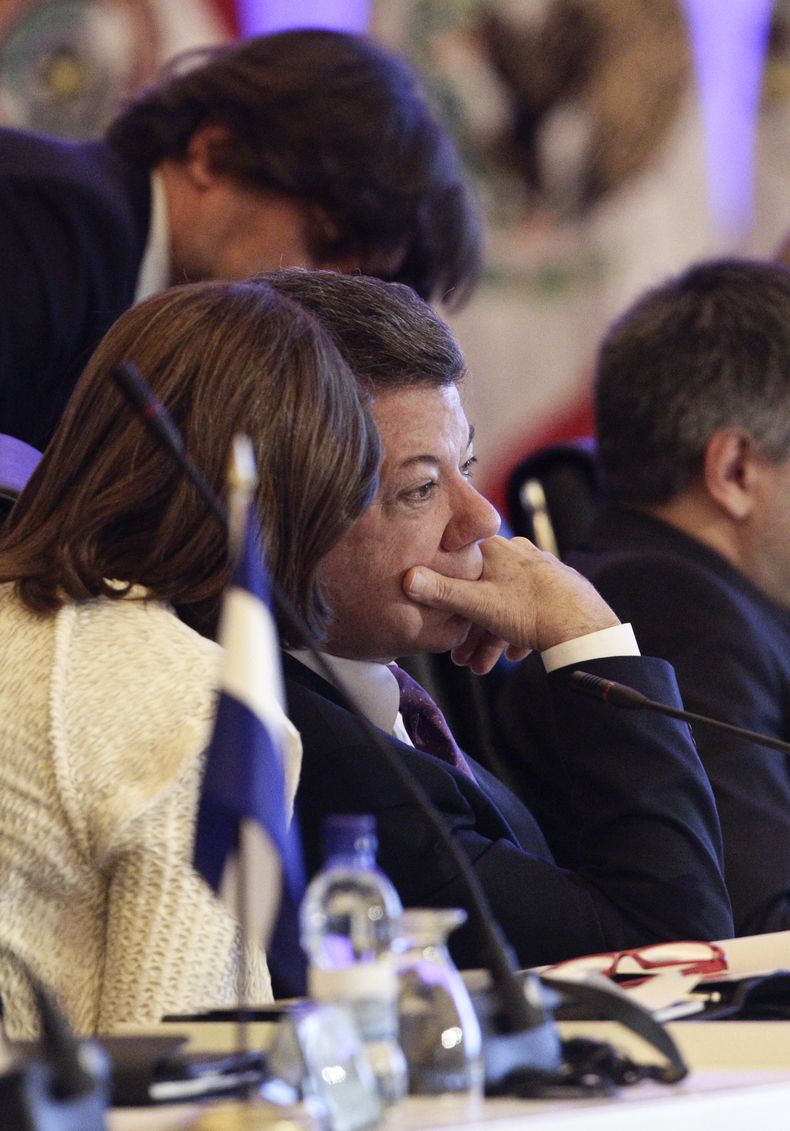 Presidente colombiano Juan Manuel Santos escucha a su canciller Mar&iacute;a Angela Holgu&iacute;n durante la Cumbre Iberoamericana en Panam&aacute;, s&aacute;bado 19 de octubre de 2013. Santos admiti&oacute; que las negociaciones de paz con las FARC no c