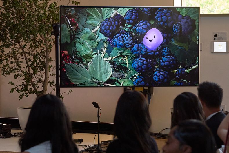 Una animación de video muestra un avatar de Copilot Appearance llamado Mico, flotando alrededor de un entorno abstracto durante una presentación en el evento Copilot Sessions de otoño de 2025 de Microsoft el miércoles 22 de octubre de 2025 en Los Ángeles. (AP Foto/Damian Dovarganes)