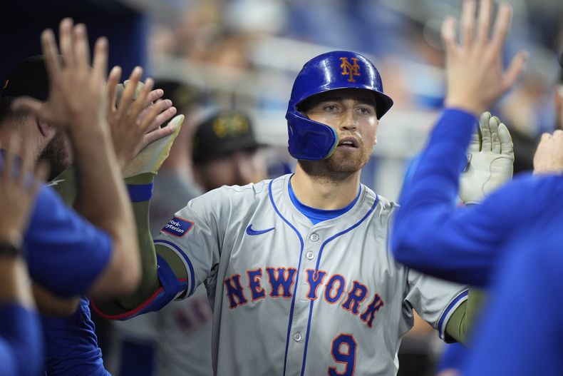 Brandon Nimmo (9), de los Mets de Nueva York, celebra con sus compañeros de equipo después de conectar un jonrón que anotó Francisco Lindor, durante la novena entrada de un juego de béisbol contra los Marlins de Miami, el domingo 19 de mayo de 2024, en Miami. (AP Foto/Wilfredo Lee)