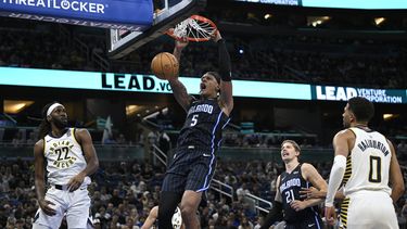 Paolo Banchero (5), del Magic de Orlando, clava el balón entre Isaiah Jackson (22) y Tyrese Haliburton (0), de los Pacers de Indiana, durante la primera mitad del juego de baloncesto de la NBA, el lunes 28 de octubre de 2024, en Orlando, Florida. (AP Foto/Phelan M. Ebenhack)
