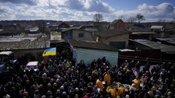 Personas se reúnen junto al cadáver de Vladyslav Bondarenko, de 26 años, durante su funeral en Kozyntsi, cerca de Kiev, Ucrania, el lunes 6 de marzo de 2023. Bondarenko, un paracaidista de una brigada aérea, murió cerca de Bájmut el 26 de febrero de 2023. (AP Foto/Thibault Camus)