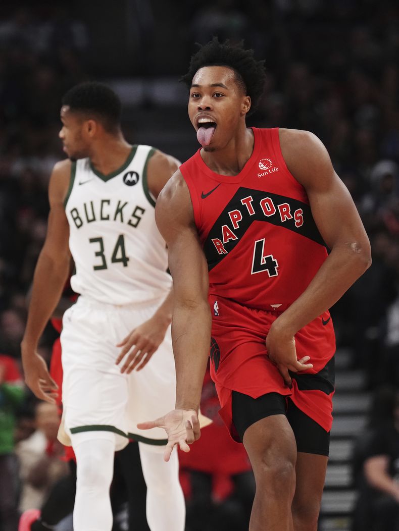 Scottie Barnes, alero de los Raptors de Toronto, festeja su enceste, cerca de Giannis Antetokounmpo, de los Bucks de Milwaukee, en el partido del miércoles 1 de noviembre de 2023 (Nathan Denette/The Canadian Press via AP)