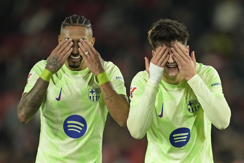 Pau Victor (derecha) celebra con Raphinha tras anotar el quinto gol del Barcelona en la victoria 5-1 ante Mallorca en la Liga española, el martes 3 de diciembre de 2024. (AP Foto/José Bretón)