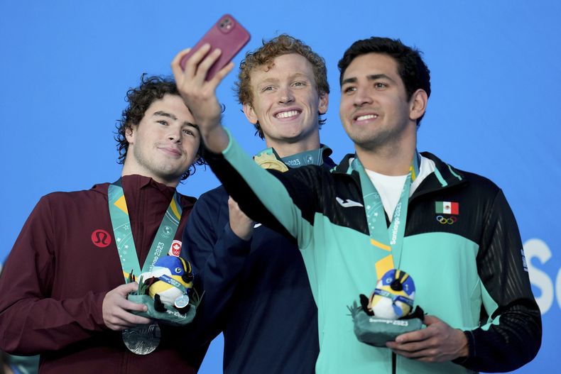 El canadiense Brayden Taivassalo, el estadounidense Jacob Foster y el mexicano Andres Puente en el podio de los 200 metros estilo pecho de la natación de los Juegos Panamericanos en Santiago, Chile, el lunes 23 de octubre de 2023. (AP Foto/Fernando Vergara)