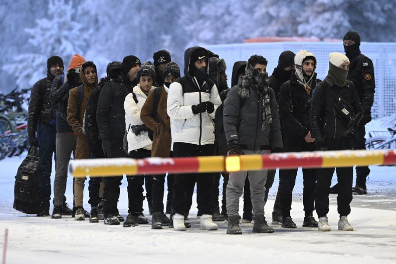 Migrantes llegan al paso fronterizo internacional entre Finlandia y Rusia, en Salla, Finlandia, jueves 23 de noviembre de 2023. (Jussi Nukari/Lehtikuva via AP)