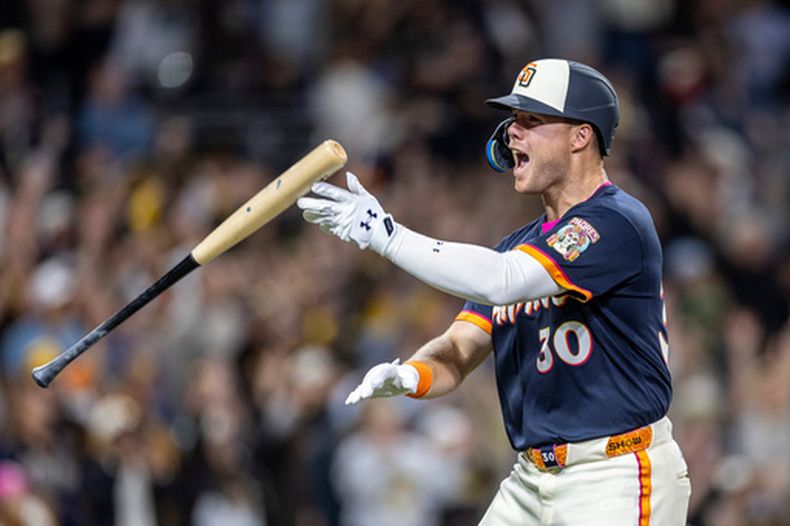 Gavin Sheets, de los Padres de San Diego, festeja tras conectar un jonrón en la novena entrada del juego del viernes 10 de abril de 2026, ante los Rockies de Colorado (AP Foto/Tony Ding)