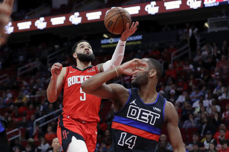 Fred VanVleet, izquierda, de los Rockets de Houston, intenta una bandeja sobre Alec Burks (14), de los Pistons de Detroit, durante la primera mitad del juego de baloncesto de la NBA, el lunes 1 de enero de 2024, en Houston. (AP Foto/Michael Wyke)