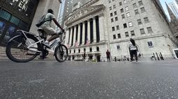 Un ciclista se acerca a la parte posterior de la Bolsa de Nueva York, el martes 9 de julio de 2024, en Nueva York. (AP Foto/Peter Morgan)
