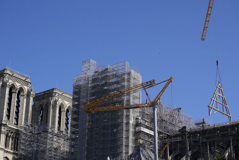 Una grúa levanta un enorme marco de roble en la catedral de Notre Dame de París, el martes 11 de julio de 2023 en París. Los paneles se volverán a montar en la parte superior de Notre Dame para reemplazar el techo que las llamas convirtieron en cenizas en 2019. (Foto AP/Christophe Ena)
