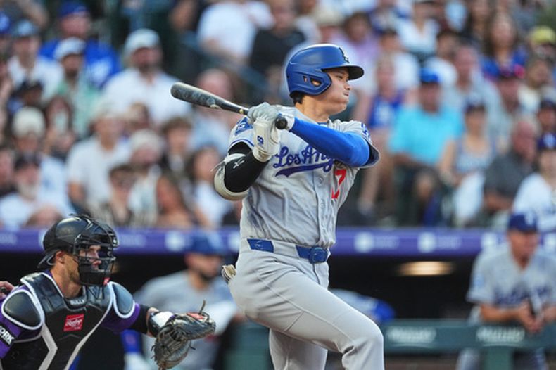 Shohei Ohtani de los Dodgers de Los Ángeles batea un sencillo en la tercera entrada ante el abridor de los Rockies de Colorado Tomoyuki Sugano el lunes 17 de agosto del 2026. (AP Foto/David Zalubowski)