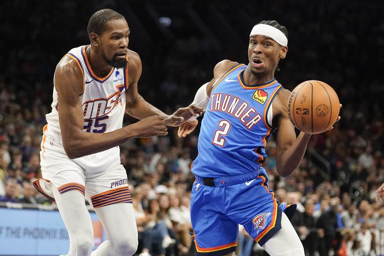 Kevin Durant (35), de los Suns de Phoenix, presiona en defensa a Shai Gilgeous-Alexander (2), del Thunder de Oklahoma City, durante la segunda mitad del juego de baloncesto de la NBA, el domingo 12 de noviembre de 2023, en Phoenix. (AP Foto/Darryl Webb)