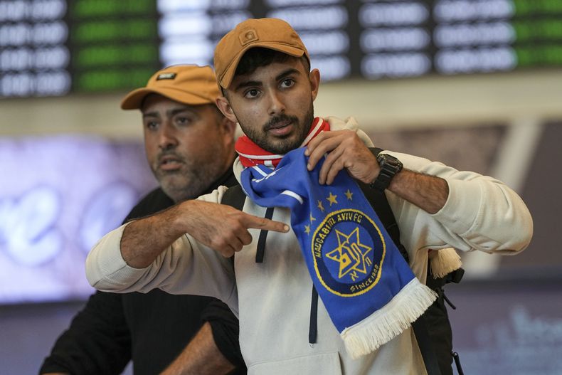 Aficionado del Maccabi Tel Aviv señala su bufanda al llegar al aeropuerto Ben-Guron en Israel proveniente de Amsterdam el viernes 8 de noviembre del 2024. (AP Foto/Tsafrir Abayov)